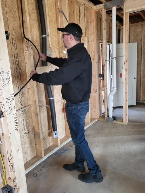 Dean inspecting wall framing and pipes