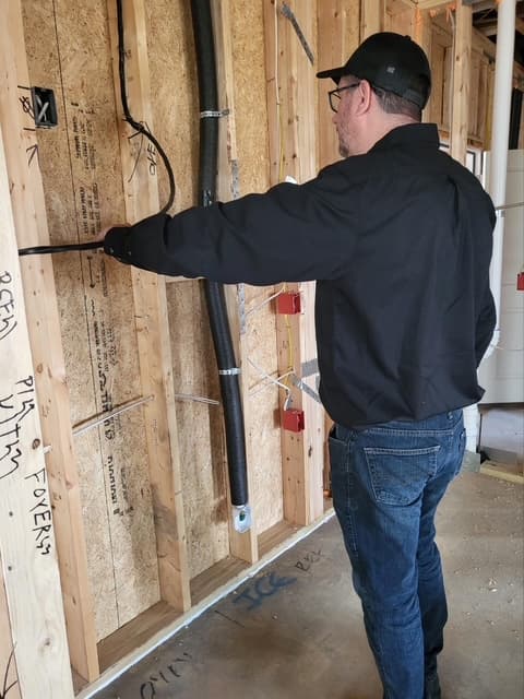 Dean checking wall pipe installation
